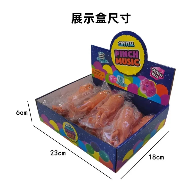 A box containing a crystal ball fidget toy with a pink and yellow label, shown from above.