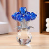 A crystal sculpture featuring a bouquet of bright blue roses on a clear glass base.