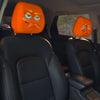 A pair of orange horror-themed car headrest covers with creepy face designs installed in a vehicle interior.