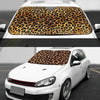 A white car with a leopard print sunshade covering the windshield.