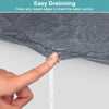 A hand is pressing a raised edge on a dark gray silicone mat to drain water quickly.