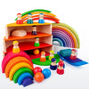 A set of wooden rainbow stacking blocks and figures used for creative building and Montessori activities.