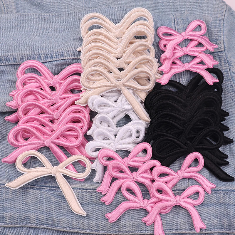 Assortment of pink, white, and black embroidered bow iron-on patches for DIY clothing decoration