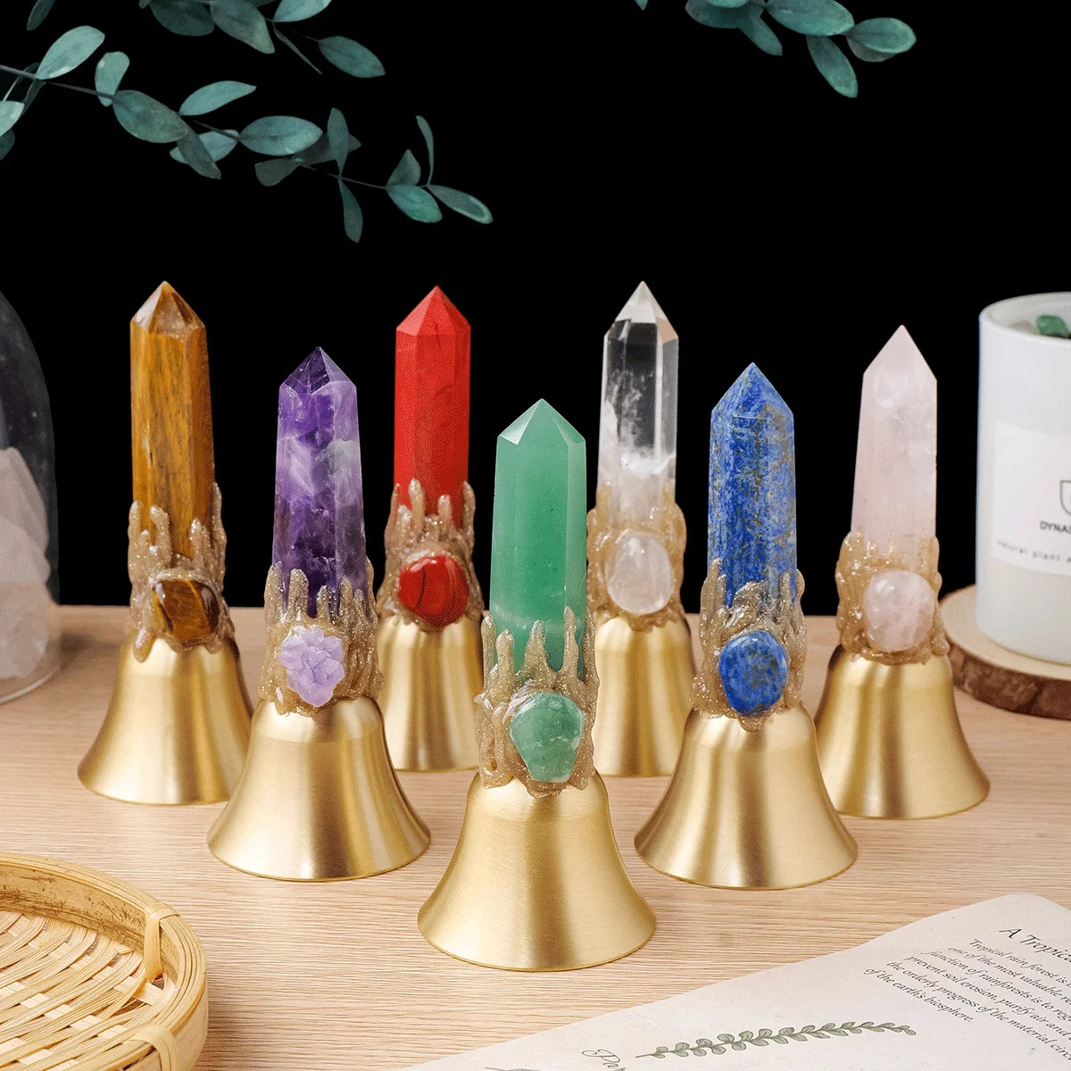 A collection of natural crystals mounted on brass bells against a dark background.