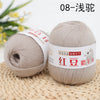 A ball of light beige yarn labeled 08-浅glue is shown next to a blurred green plant.