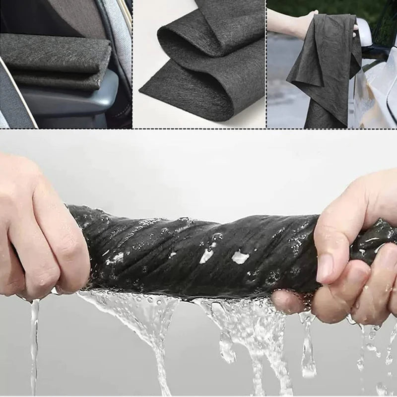 Hands are squeezing a thick black microfiber cleaning cloth that is dripping water.