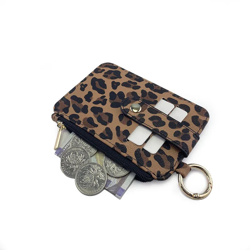 A brown leopard print PU leather card holder with a zippered coin pocket and a gold-colored keychain.