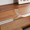 Nahaufnahme transparenter PVC-Sicherheitsstreifen, die auf die Kante eines Holztisches oder Möbelstücks aufgebracht werden.