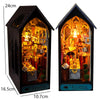 A wooden book nook kit featuring an illuminated miniature restaurant scene with detailed architecture and lighting.