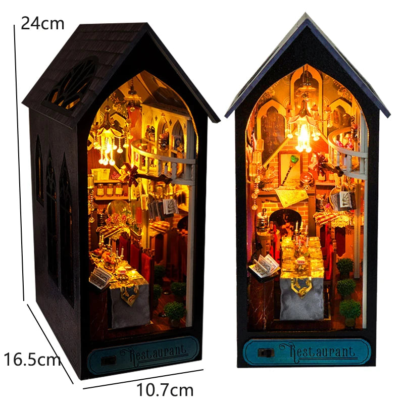 A wooden book nook kit featuring an illuminated miniature restaurant scene with detailed architecture and lighting.