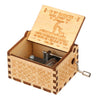 A vintage hand-cranked wooden music box with a lid featuring a message to a daughter and a small wooden box.