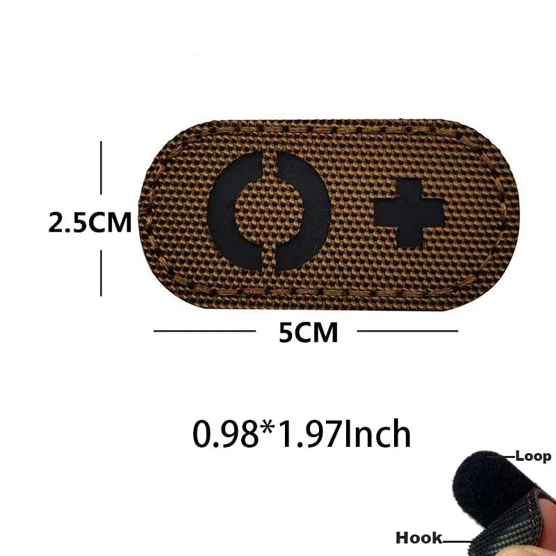 A brown glow-in-the-dark tactical patch with a circular symbol and a cross, featuring a hook and loop backing.