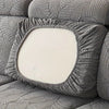 A close-up of a gray stretch jacquard sofa cover featuring a leaf pattern and a square cushion.