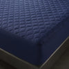 A close-up view of a dark blue quilted waterproof mattress protector with deep pockets.