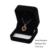 A black velvet box containing a silver heart-shaped pendant necklace.