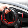Une main tient une bobine de joints pour portes de voiture rouge et noire pour l'isolation phonique.