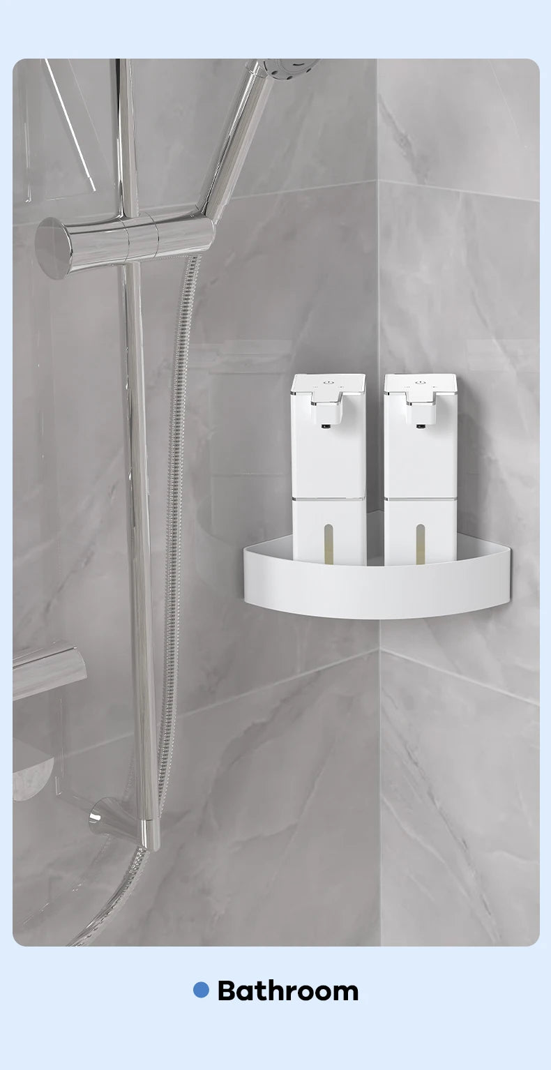 A white touchless infrared smart soap dispenser mounted on a marble wall in a bathroom.