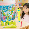 A young girl is holding a yellow fishing game with a green fish, next to the box and other parts.
