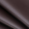 Close-up of dark brown self-adhesive PU leather repair patches being applied to a material.