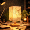 A Chinese style dimmable table lamp with a textured linen shade illuminates a workspace.