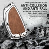 A silver zinc alloy car key case with a brown textured finish is shown against a background of scattered black rocks.