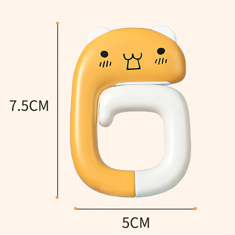 A yellow and white portable bag hook shaped like a cat, measuring 7.5cm by 5cm.