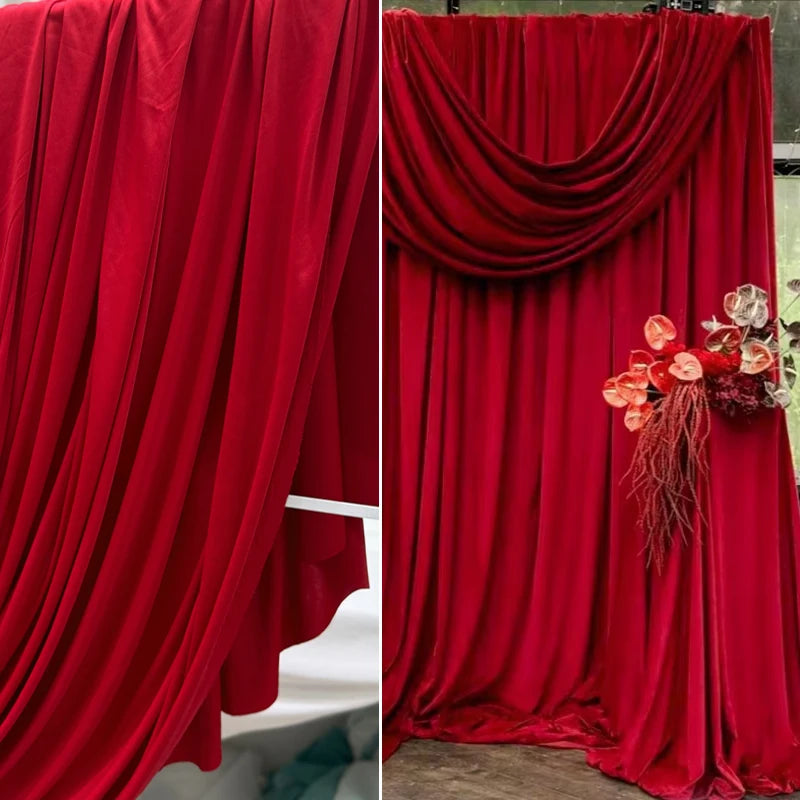 A close-up of elegant burgundy stretch jersey fabric draped in a flowing curtain style for decor.