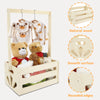 A wooden storage crate with a long handle is shown holding baby clothing and toys, highlighting its natural wood, smooth surf
