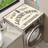 A laundry room featuring a stainless steel washer and dryer with a decorative mat on top.