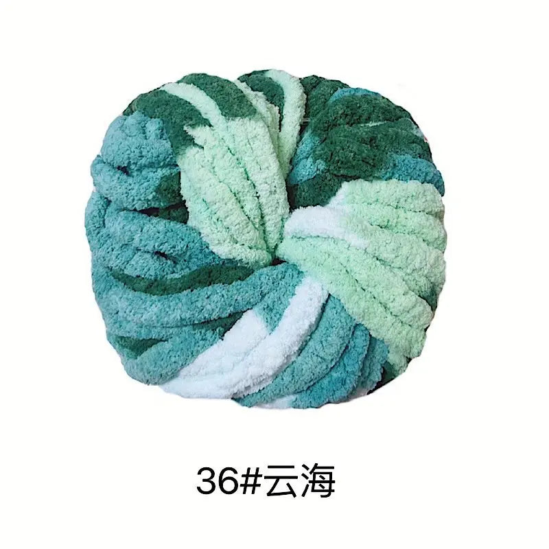 A ball of teal and light green chunky acrylic yarn for knitting and crochet