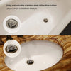 Close-up view of a white bathtub drain featuring a stainless steel hair catcher.