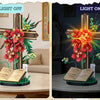 A faith floral cross building set with a wooden cross, red and orange flowers, and an open book displayed in a room setting.