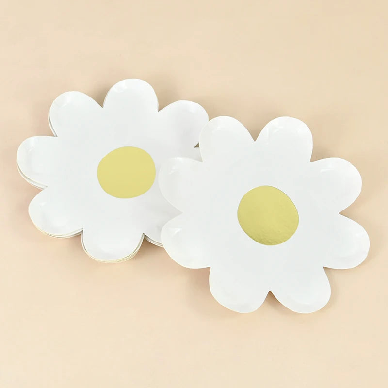 A set of white daisy flower disposable party tableware with gold centers.