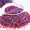A pile of red and blue rhinestones scattered on a white dish.