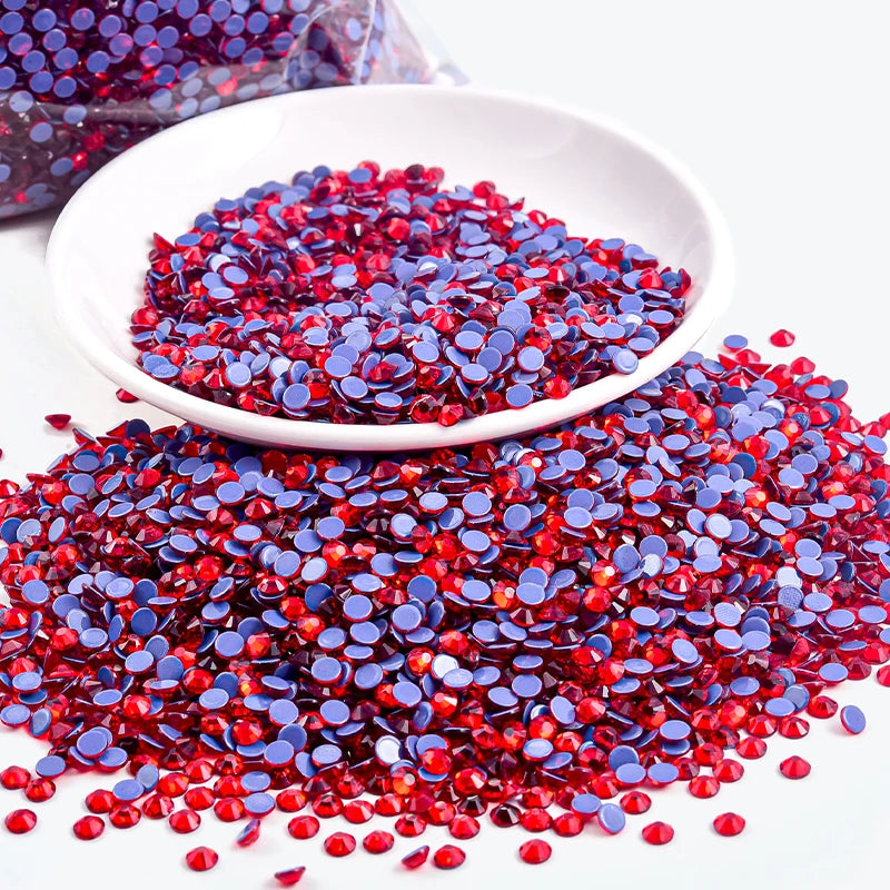 A pile of red and blue rhinestones scattered on a white dish.