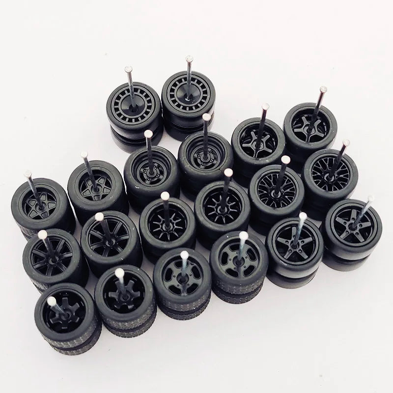 Ten pairs of black 1:64 scale alloy car wheels and tires arranged on a white background.