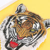 A detailed embroidery patch depicting a tiger's face in orange and black stripes on a yellow background.