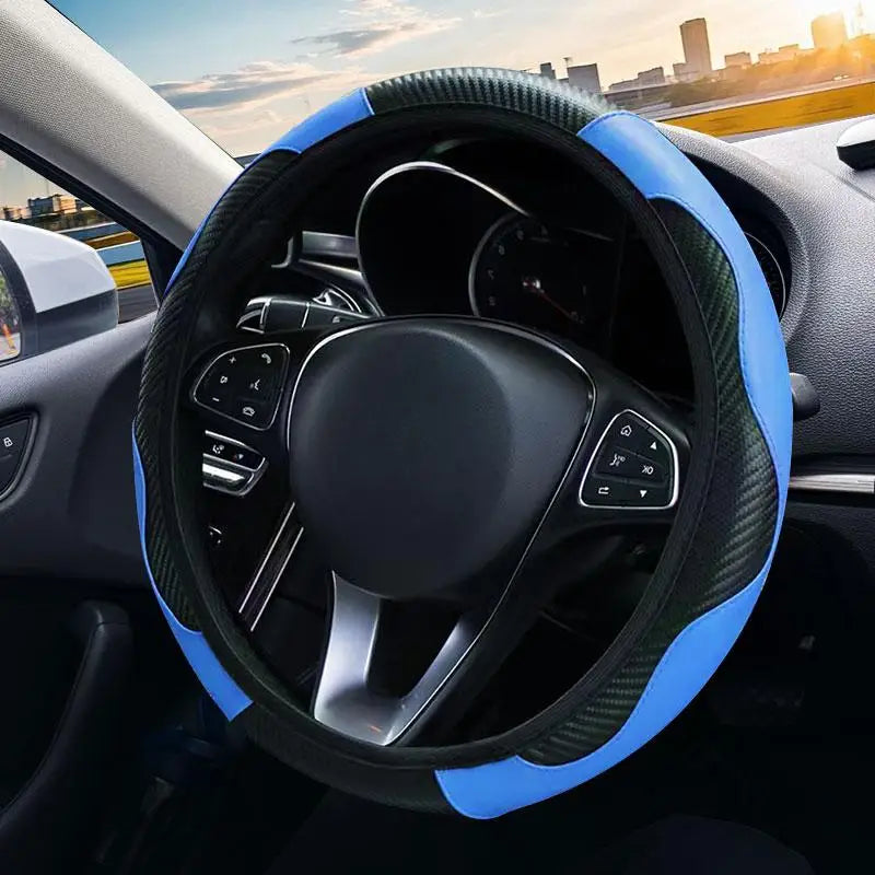Close-up view of a black steering wheel with a blue patterned cover and controls inside a car interior.