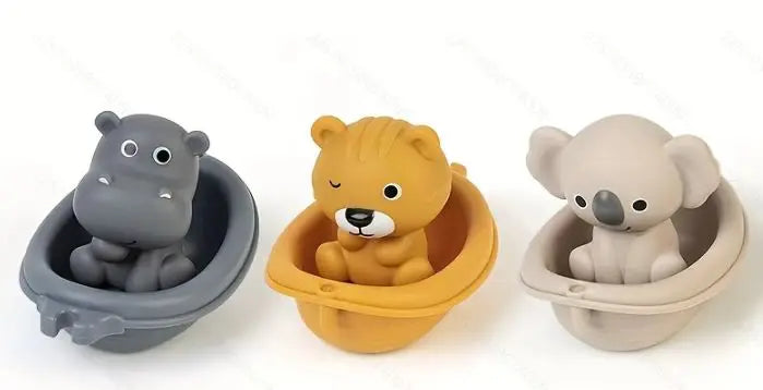 Three soft silicone bath toys shaped like an elephant, lion, and bear in various shades of gray and yellow.