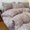 A set of soft printed duvet covers and pillowcases in a lavender floral pattern displayed on a bed.