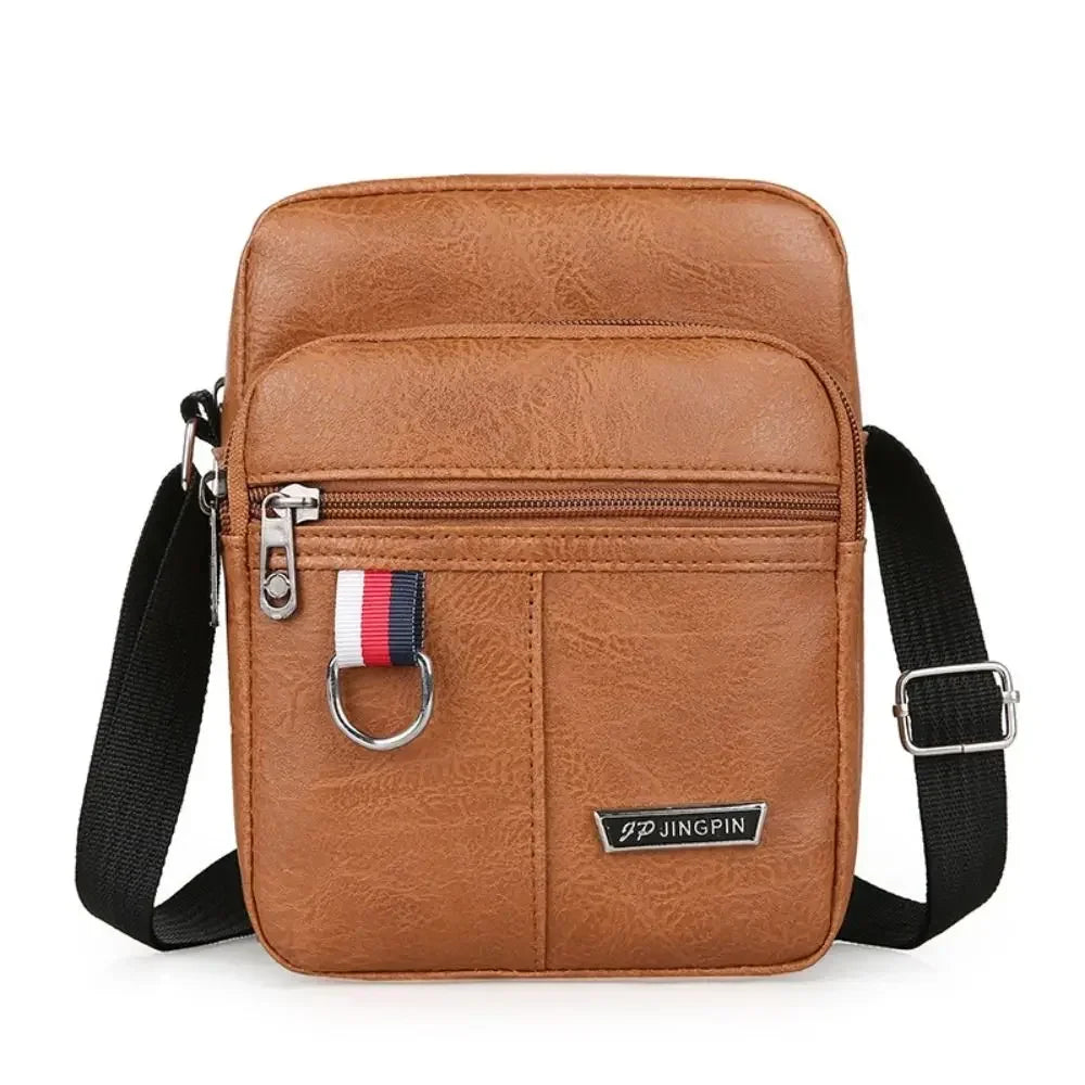 Sac bandoulière en cuir marron pour homme avec sangle noire et étiquette rayée.