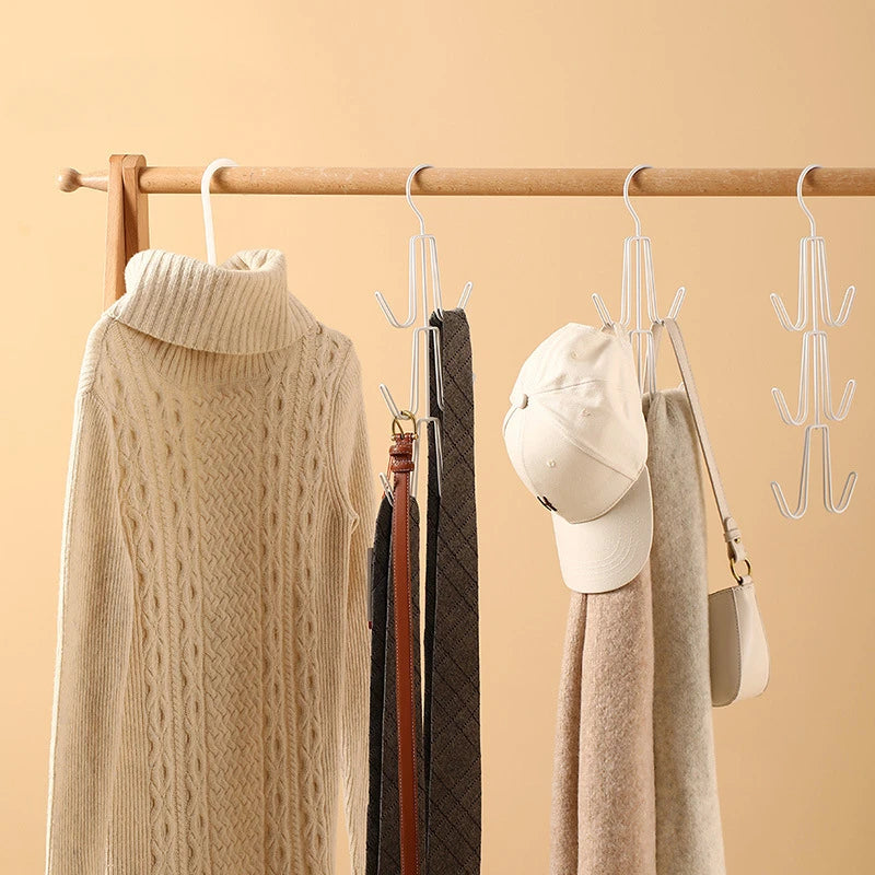 A wooden hanger displays a beige knitted sweater, a white cap, and various fabric items hanging from a multi-layered organize