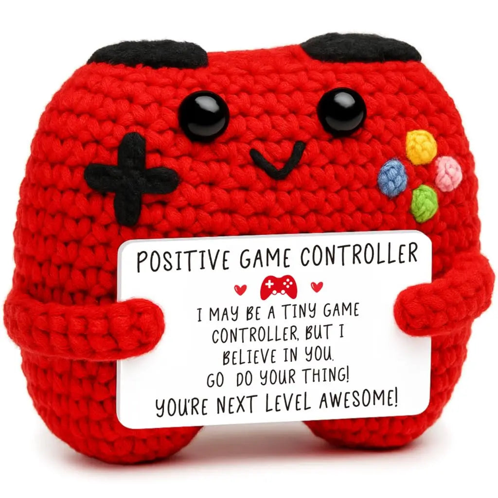 A handmade red crochet game controller decoration with black eyes and colorful embellishments.