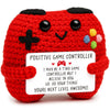 A red crocheted plush game controller shaped like a dinosaur with a smiling face.