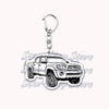 A silver metal key ring attached to a miniature model of a Ford F-150 off-road truck.