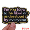 Black embroidered iron-on patch with pink text that reads I'm not here to be liked or understood by everyone