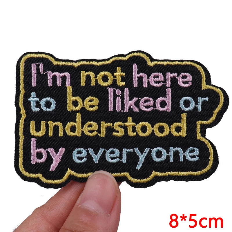 Black embroidered iron-on patch with pink text that reads I'm not here to be liked or understood by everyone
