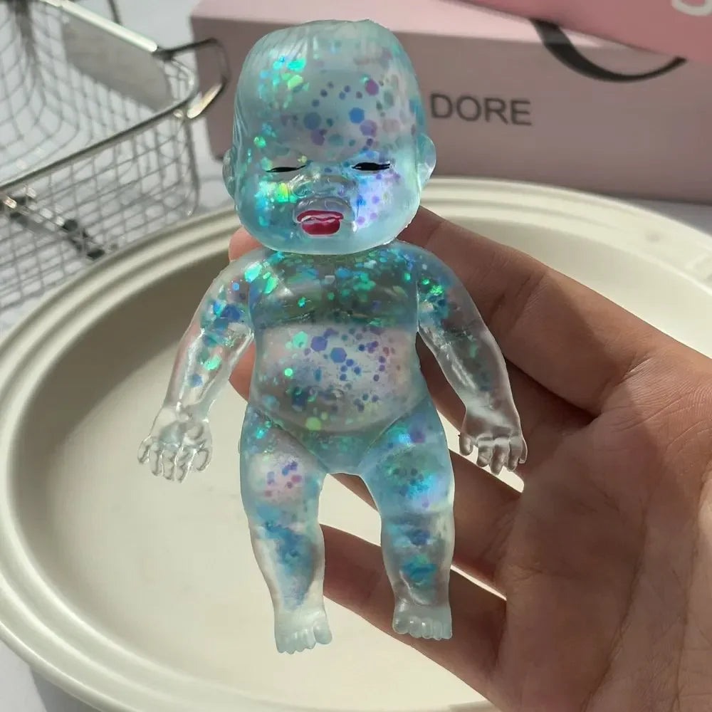 A translucent blue squishy stress relief toy with a shimmering finish and small colored dots is held in a hand.