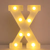 A glowing yellow LED letter night light shaped like the letter X, illuminating various points.