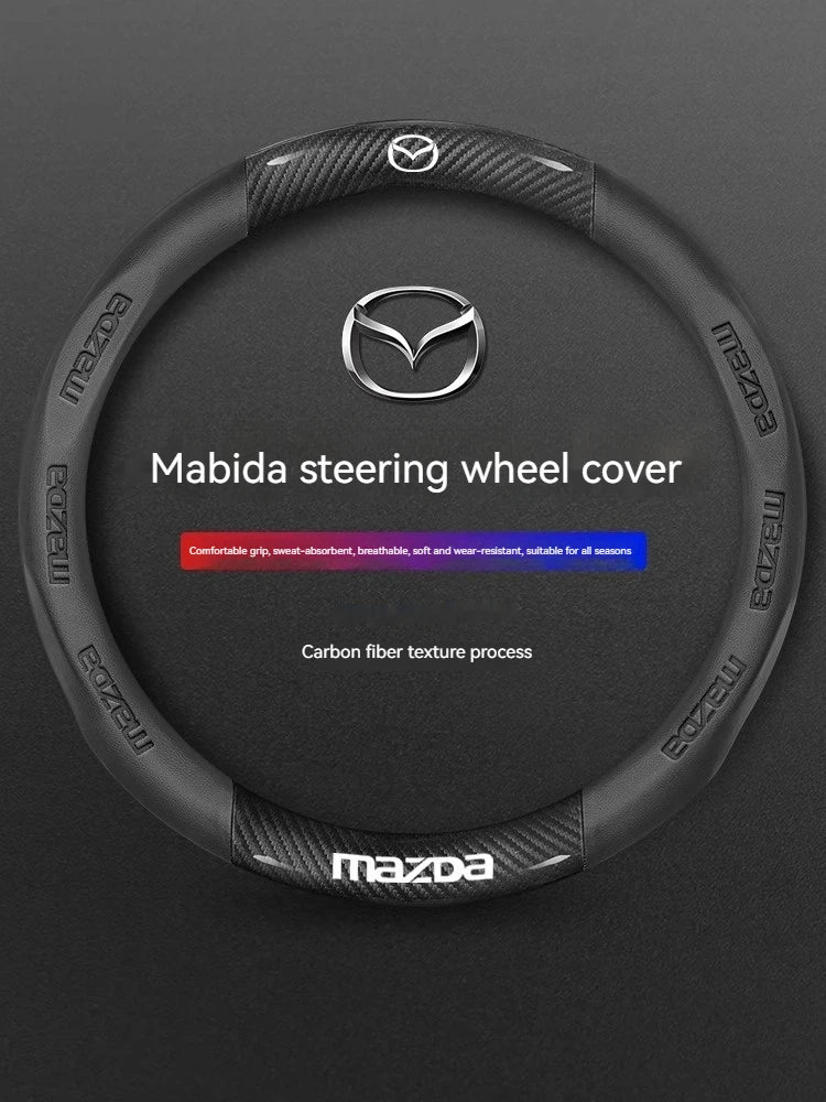 Black carbon fiber steering wheel cover for Mazda models featuring the Mazda logo and text